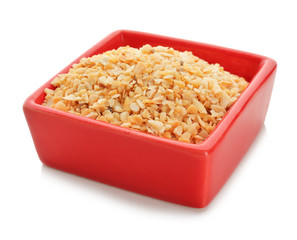 Bowl with granulated dried garlic on white background