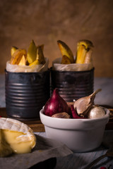 Few onions and garlics in white bowl and fried potato stripps