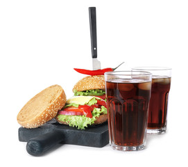 Glasses of cold cola with tasty burgers on white background