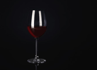 Glass with red wine on black background