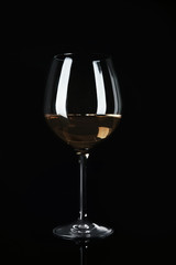 Glass with white wine on black background