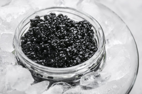 Black caviar served with ice in glass bowl