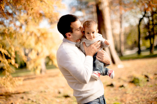 Young father and baby boy in autumn park