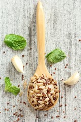 Cooked Quinoa brown rice in a wooden spoon on rustic white background, selective focus