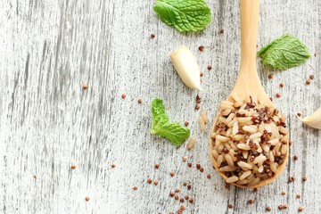 Cooked Quinoa brown rice in a wooden spoon on rustic white background, selective focus