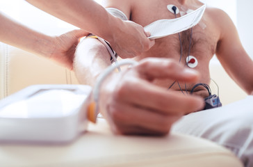 Close up man tested with Holter monitor hand with Sphygmomanometer