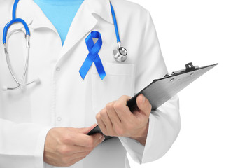 Doctor with blue ribbon on white background, closeup. Prostate cancer awareness