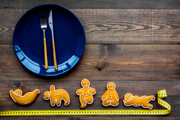 Sport and healthy diet for slimming. Plate, measuring tape and cookies in shape of yoga asans on...