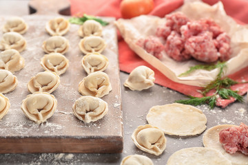 Raw dumplings and minced meat on table