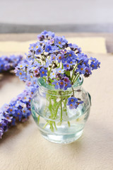 Bouquet of forget-me-not flowers in glass vase.