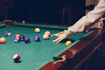 Hand holding billiard stick cue ready to shot ball