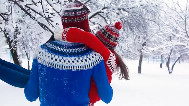Happy couple in love having fun in winter. Young man whirling his girlfriend