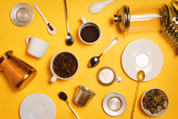 Various coffee making accessories, equipment and utensils: cezve, french press, vietnamese Phin filter etc. Top view, yellow background. Flatlay