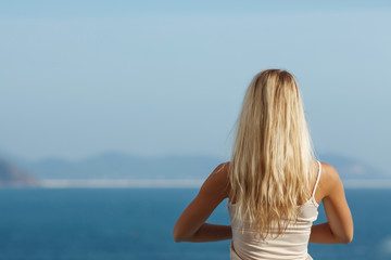 Fototapeta na wymiar Young woman doing yoga outdoor, sea view