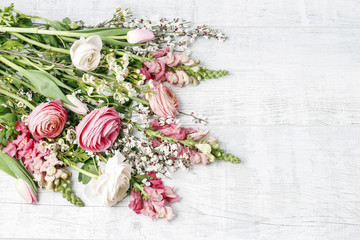 Bouquet of spring flowers on white wooden background