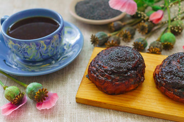 a fine breakfast, a mug of tea, fresh rolls with poppy seeds and poppy flowers.