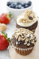 Muffins decorated with fresh fruits and oatmeal flakes