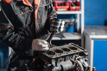 the mechanic installs a new piston. Disassemble engine block vehicle. Motor capital repair. Sixteen...