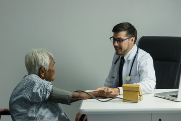 Male Doctor listening heart beat and breathing of Elderly Woman with Stethoscope with First Aid Medical Box.Community Health and Development Hospital In Remote Areas Development Fund Concept.