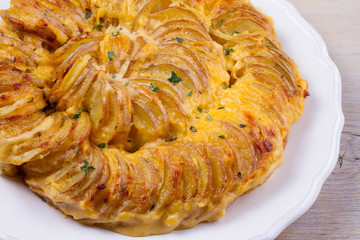Potato gratin on white plate. Baked potato slices with creamy sauce. horizontal