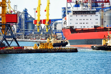 Tugboat assisting bulk cargo ship
