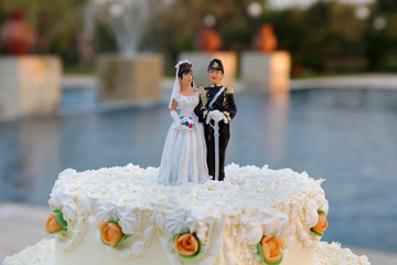Wedding cake with the decoration of the bride and groom on top