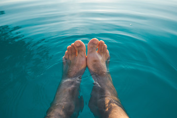 Male feet in outdoor swimming pool