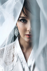 Beautiful bride covered with light bridal veil