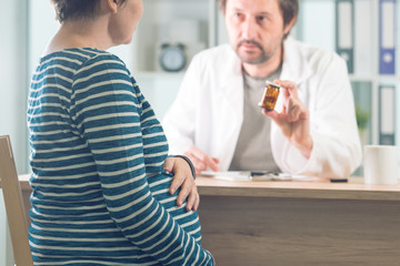 Doctor prescribing pills to pregnant woman