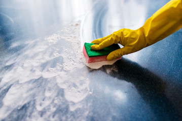 A hand in a glove, wiping dirt.