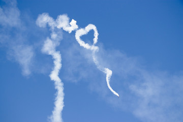 Heart shape from a white smoke trail on the sky from an aeroplane