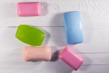 Set of colorful soap on white wooden background
