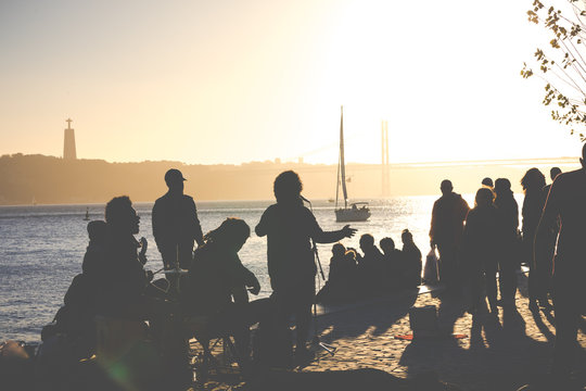 Silhouettes of people at a concert at sunset time in Lisbon, Portugal.