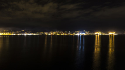 Fototapeta na wymiar Triest in Italy at night skyline view of harbor sea. Shot taken from Muggia
