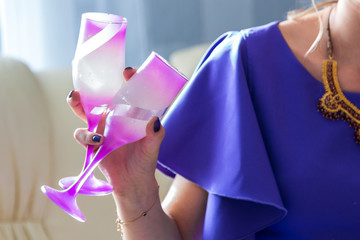 Girl holds two pink glasses for champagne in her hand