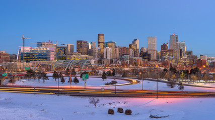 Denver Skyline at Winter Dusk - Panoramic winter evening view of Downtown Denver, looking from west side of the city, next to the busy US Interstate  Highway 25. Colorado, USA. - obrazy, fototapety, plakaty