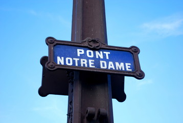 A sign post at the bridge leading to the Notre Dame Cathedral in Paris, France