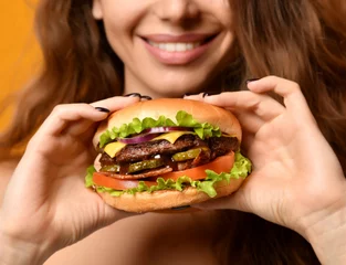Fotobehang Woman eat burger sandwich with hungry mouth on yellow background © Dmitry Lobanov