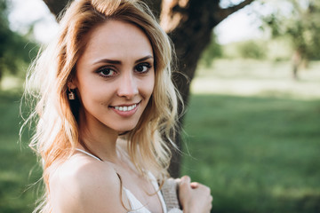 Naklejka premium Portrait of a charming smiling girl which spends time in the park
