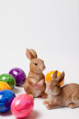 Zwei glückliche Osterhasen und bunte Ostereier.