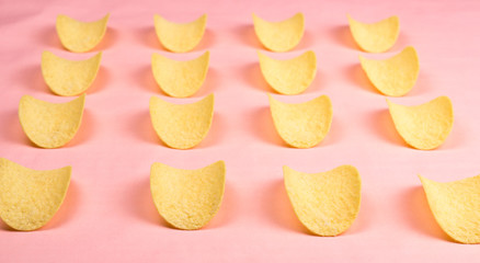 Potato chips on pastel pink background in minimalism style.