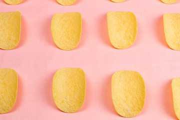 Potato chips on pastel pink background in minimalism style.