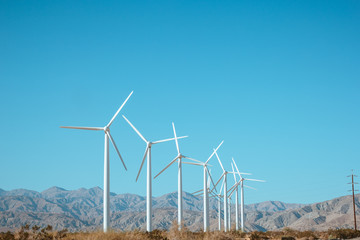 Wind generator against the blue sky and beautiful landscape