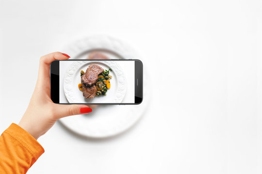 Girl takes a photo of her meal with smartphone for her social media