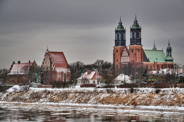 Urban landscape with river Warta and the cathedral towers in winter in Poznan.