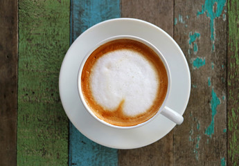 Hot Coffee with Heart Shaped Latte Art in a White Cup on Colored Rustic Style Wooden Table,Top View with Selective Focus