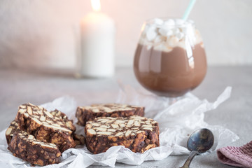 Pieces of chocolate cake from cookies and cocoa with marshmallow on bakery paper