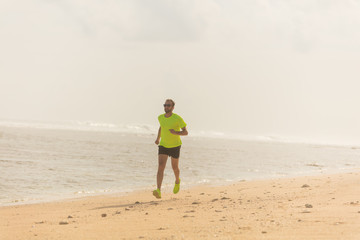 Jogging on a tropical sandy beach near sea / ocean.