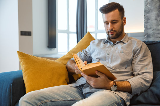 Bachelor man daily routine in the living room single lifestyle concept reading book