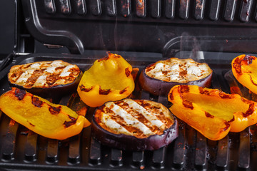 Vegetables: aubergines and yellow pepper on an electric grill. Close-up. Healthy Eating